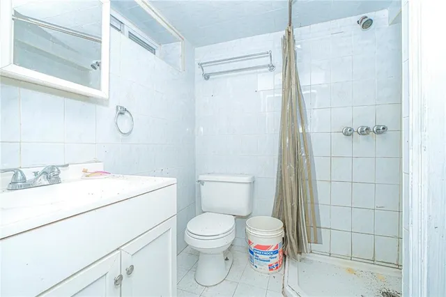 a bathroom with a toilet sink vanity and shower