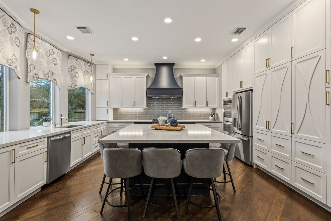 20102 Windbury Court Spring, TX 77379 - Photo 14 of 49 This custom kitchen has a grand island that provides a comfortable place to sit and talk. Cabinets with lighting under and above provide loads of storage space. Everything can be hidden from view.