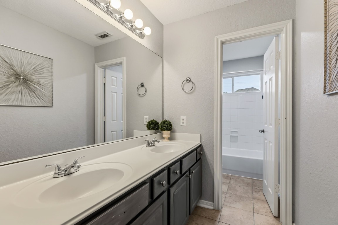 20102 Windbury Court Spring, TX 77379 - Photo 26 of 49 This upstairs bathroom has two sinks and the shower area is separated by a door, so multiple people are able to get dressed at once.