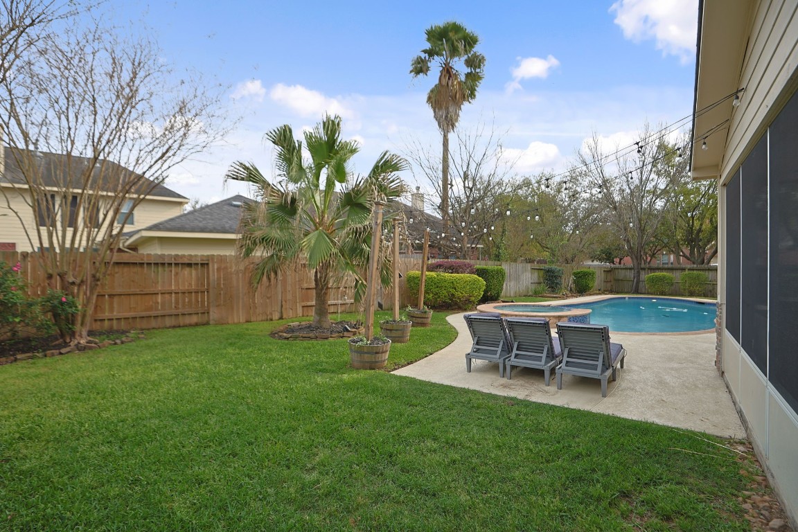 20102 Windbury Court Spring, TX 77379 - Photo 34 of 49 Lush landscaping frames the gorgeous pool, and you can see the screened in patio to the right.