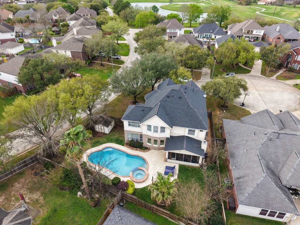 20102 Windbury Court Spring, TX 77379 - Photo 35 of 49 Drone footage of the back of the house, with the screened in patio, the pool, and another patio for poolside relaxing!