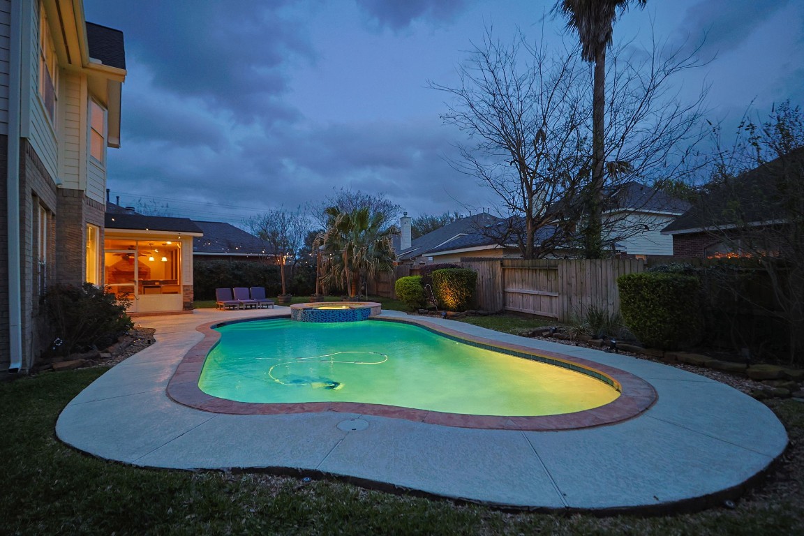 20102 Windbury Court Spring, TX 77379 - Photo 4 of 49 Lovely view of the pool at night. You can see the glow of the lights from the screened in, covered patio to the left.