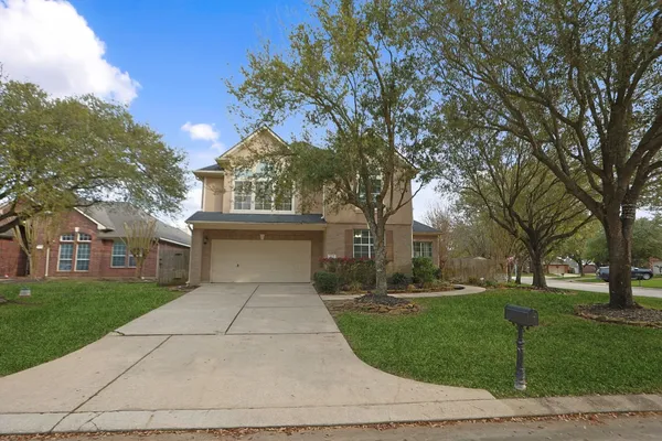 a front view of a house with a yard and trees