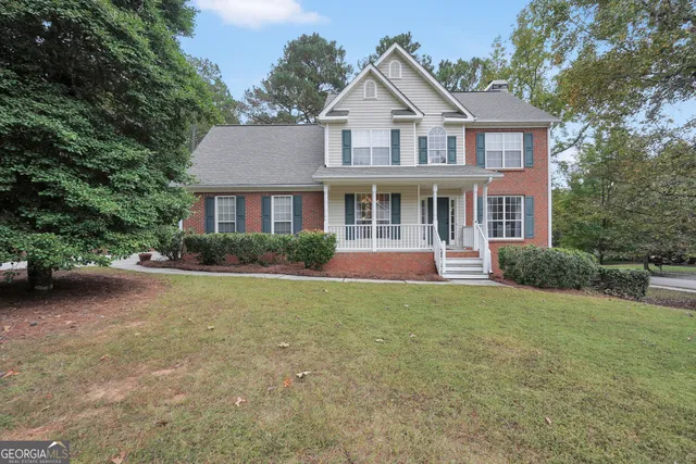 a front view of a house with a yard and potted plants