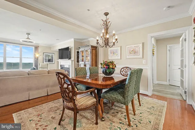 a kitchen with stainless steel appliances granite countertop a stove top oven a sink dishwasher a dining table and chairs with wooden floor