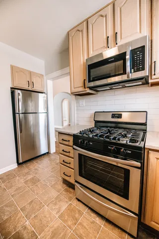 a kitchen with stainless steel appliances a stove a microwave and a refrigerator