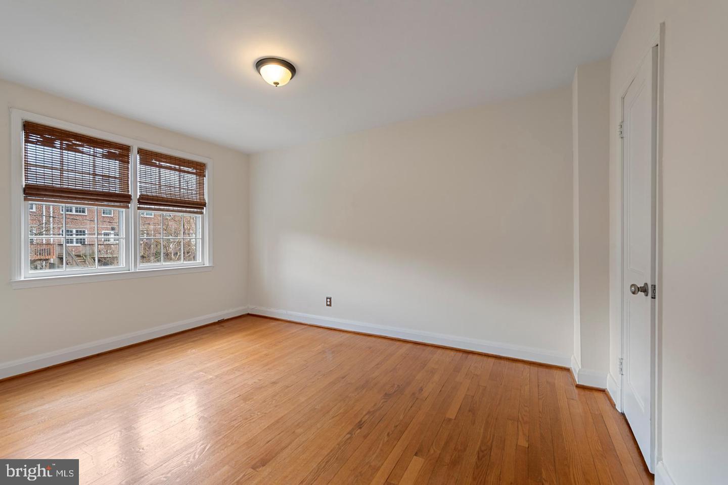 183 Stanmore Road Baltimore, MD 21212 - Photo 17 of 32 an empty room with wooden floor and windows