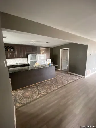 a kitchen with granite countertop a refrigerator and a sink