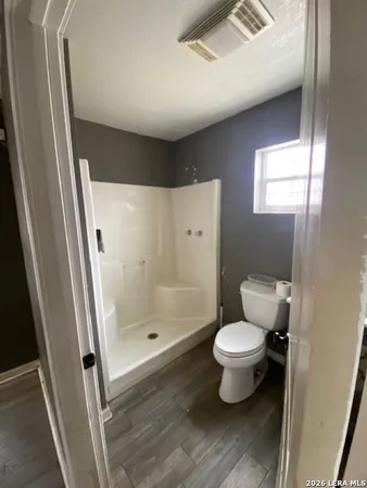 a bathroom with a toilet and a shower