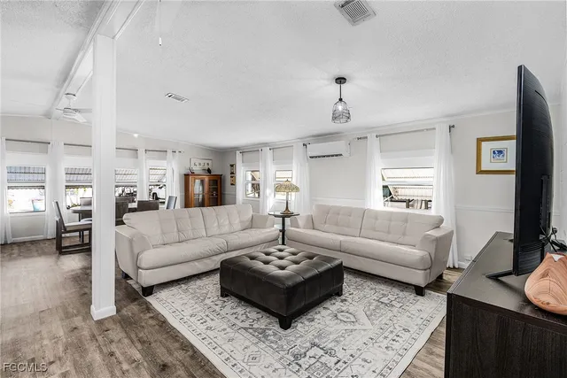 a living room with furniture a rug and a flat screen tv
