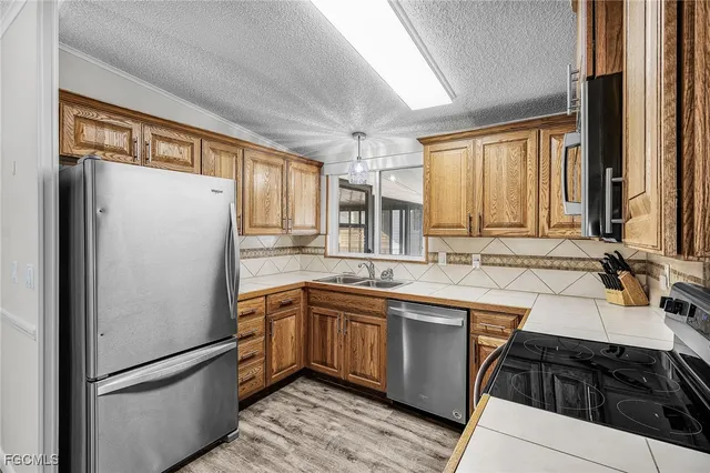 a kitchen with stainless steel appliances a refrigerator sink and cabinets