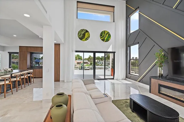 a living room with furniture a wooden floor and a large window