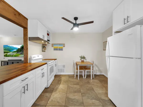 a kitchen with granite countertop a refrigerator a stove and a sink