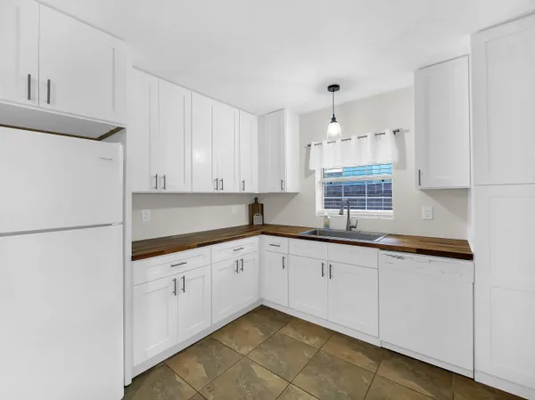 a kitchen with granite countertop white cabinets and white appliances