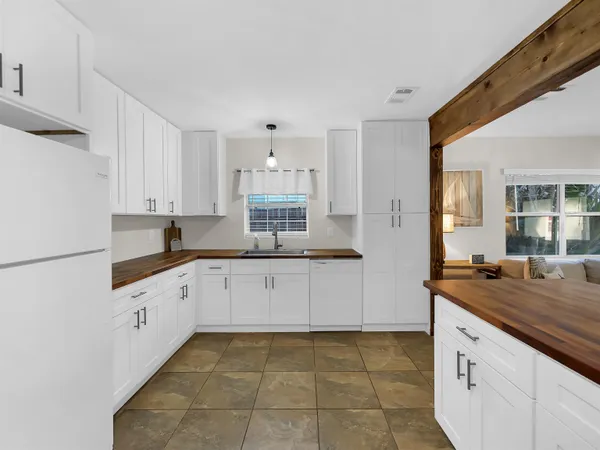 a kitchen with granite countertop white cabinets and white appliances