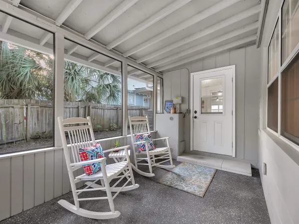a living room with patio furniture and a flat screen tv
