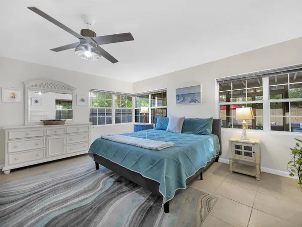 a bedroom with a large bed a chandelier and windows