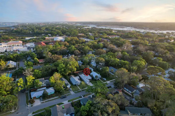 an aerial view of residential houses with outdoor space and ocean view