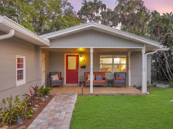 a view of a house with porch and garden