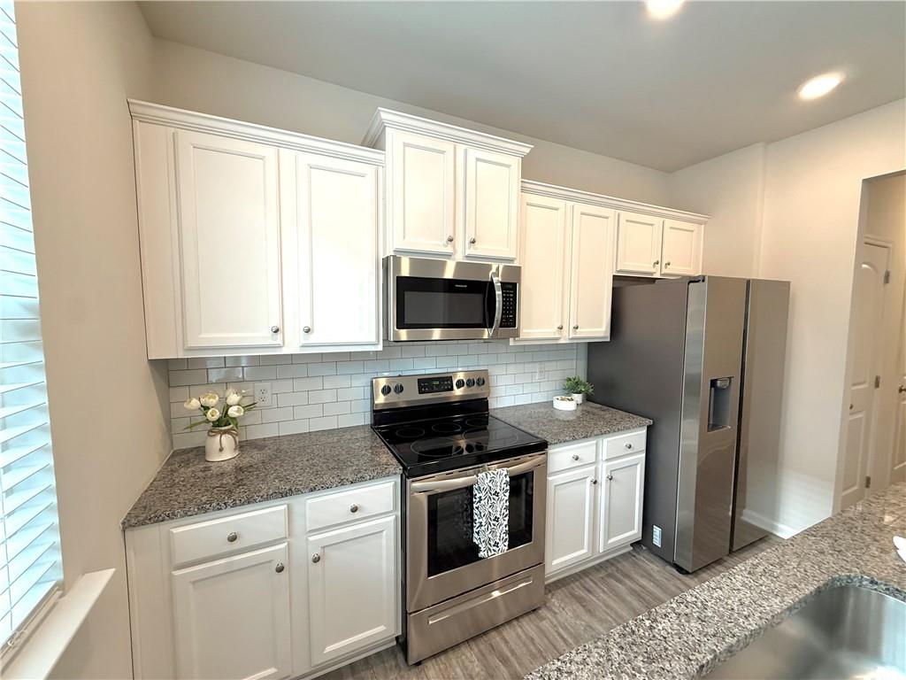 276 Whitetail Circle Canton, GA 30115 - Photo 13 of 40 a kitchen with granite countertop a refrigerator stove and microwave