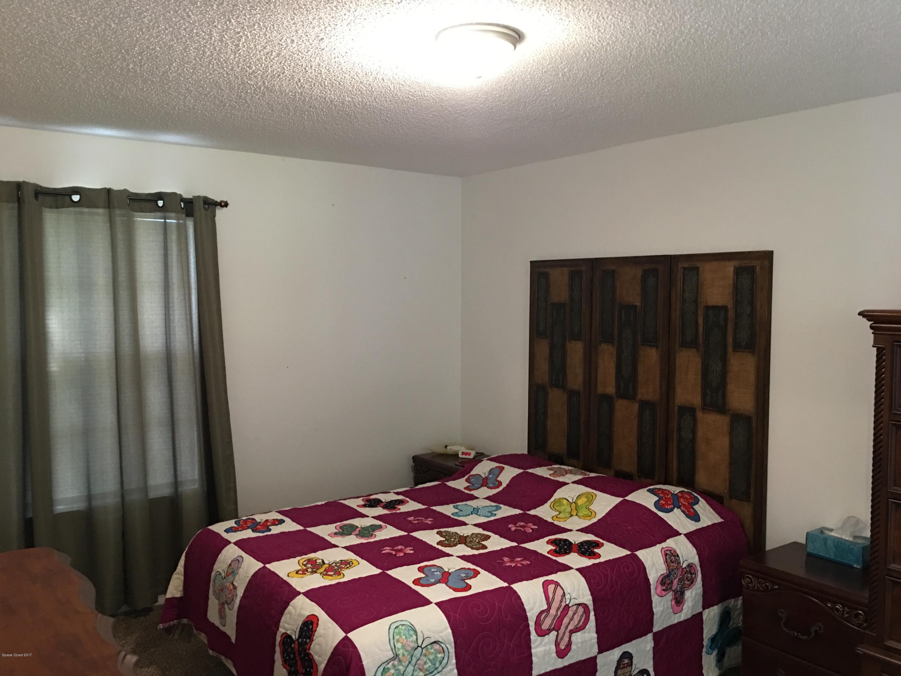 853 Furth Road Northwest Palm Bay, FL 32907 - Photo 14 of 29 a bedroom with a bed and a mirror