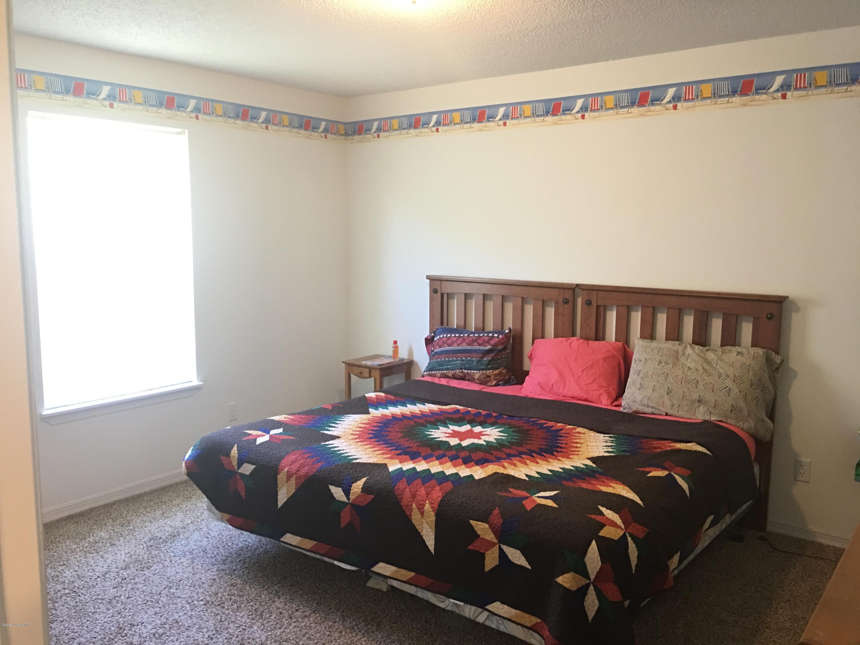 853 Furth Road Northwest Palm Bay, FL 32907 - Photo 16 of 29 a bed sitting in a bedroom next to a window