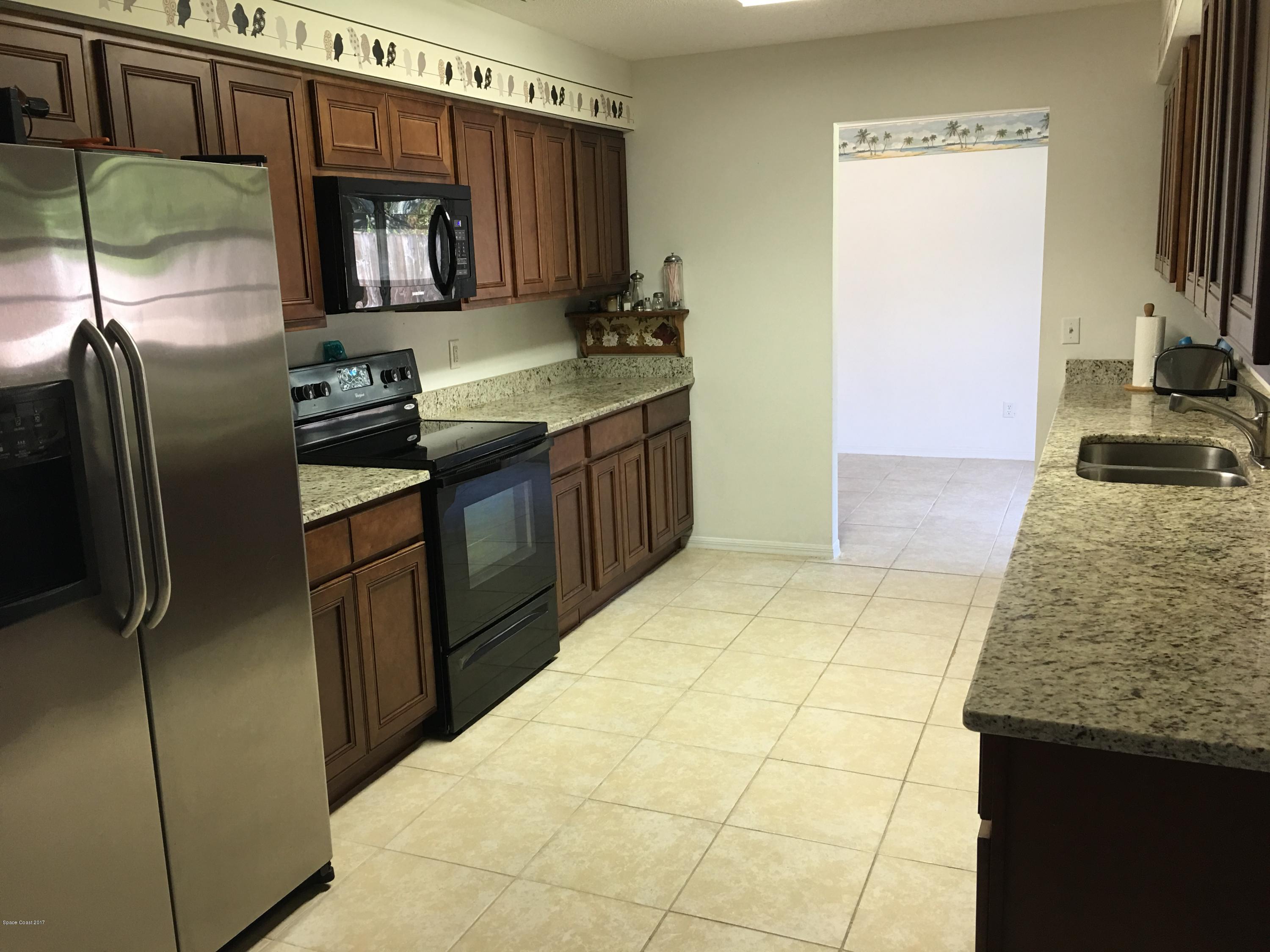 853 Furth Road Northwest Palm Bay, FL 32907 - Photo 3 of 29 a kitchen with stainless steel appliances granite countertop a sink stove and refrigerator