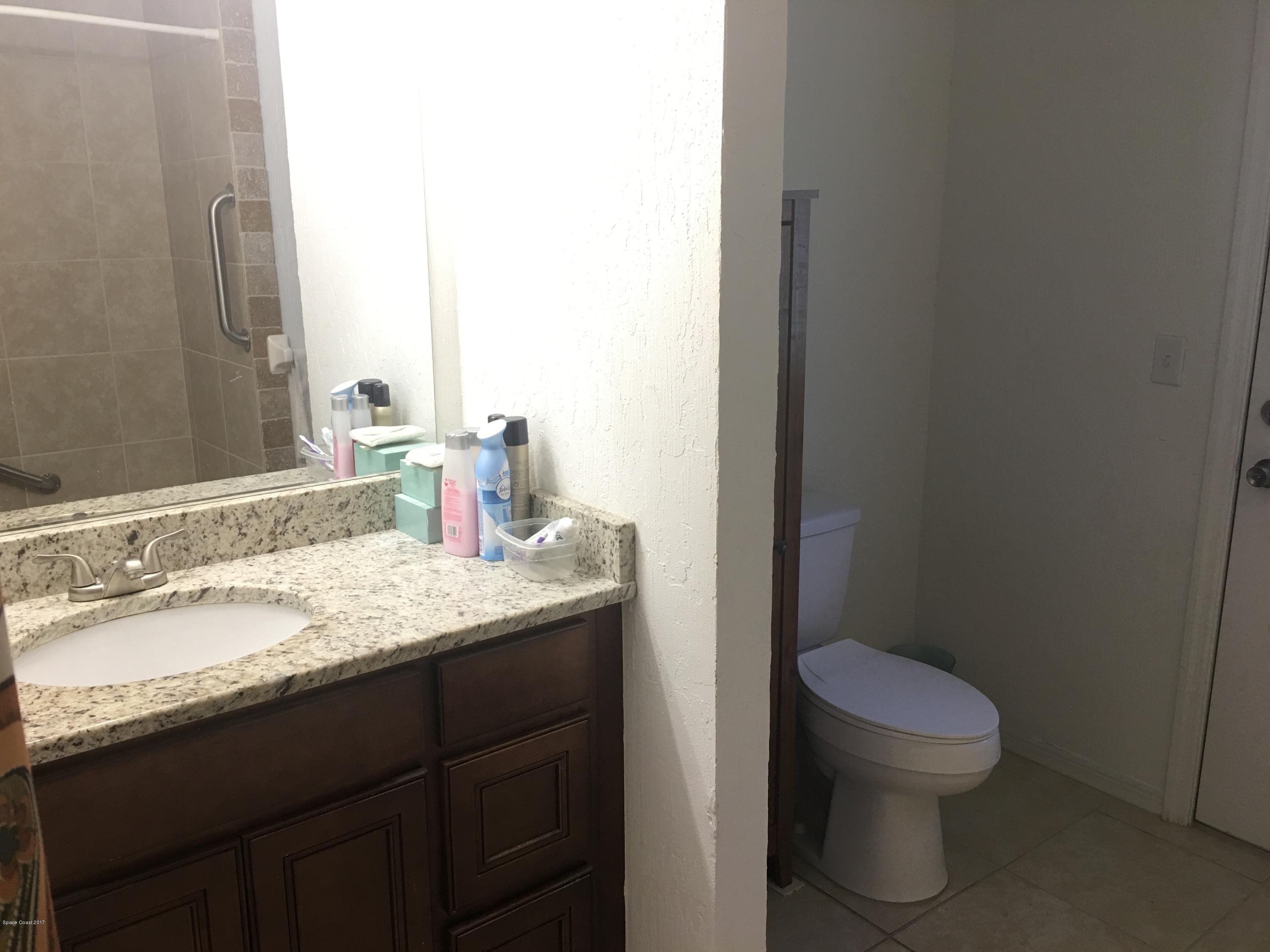 853 Furth Road Northwest Palm Bay, FL 32907 - Photo 22 of 29 a bathroom with a granite countertop sink a toilet and a mirror