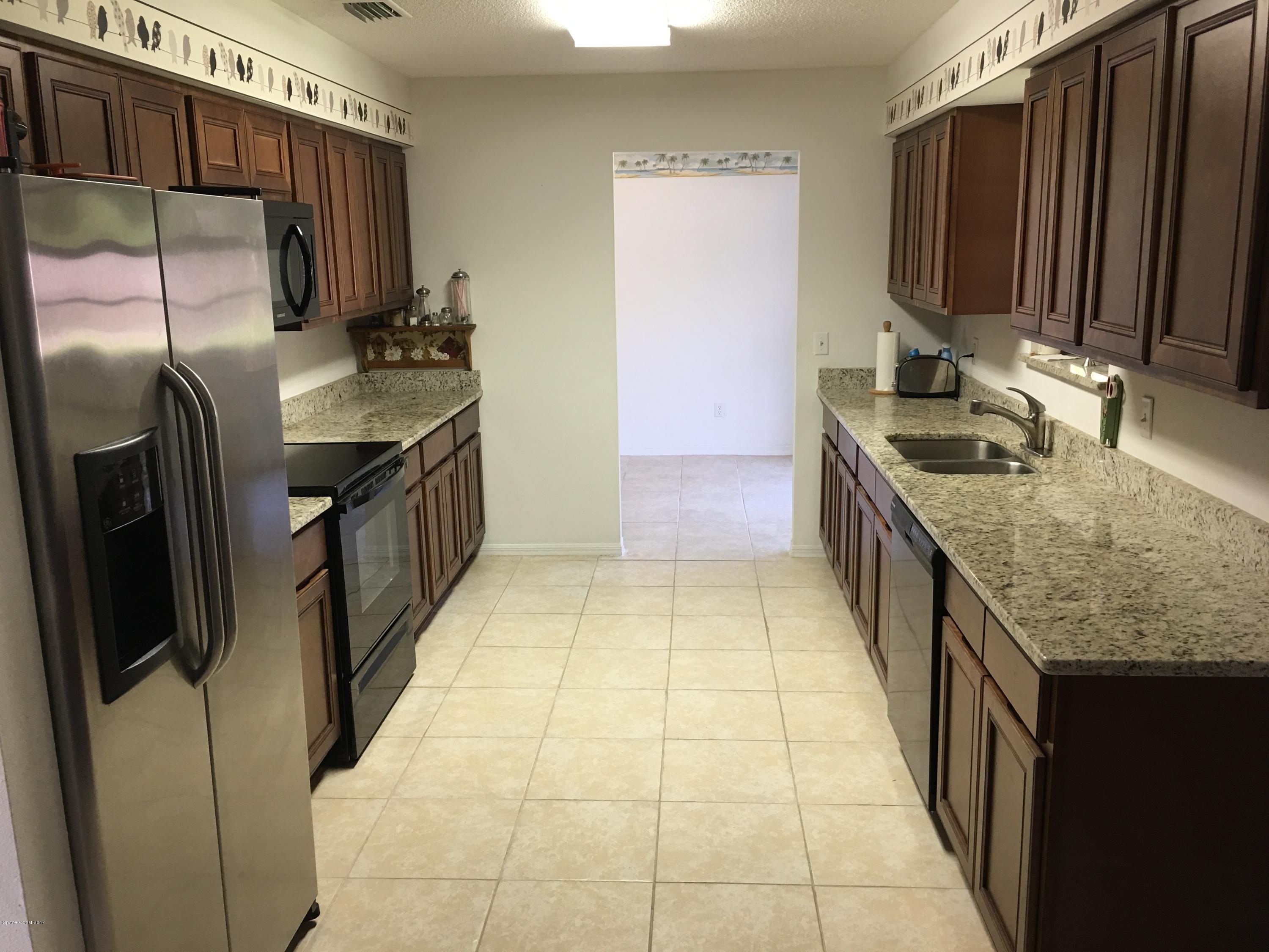 853 Furth Road Northwest Palm Bay, FL 32907 - Photo 4 of 29 a kitchen with stainless steel appliances granite countertop a sink stove and refrigerator
