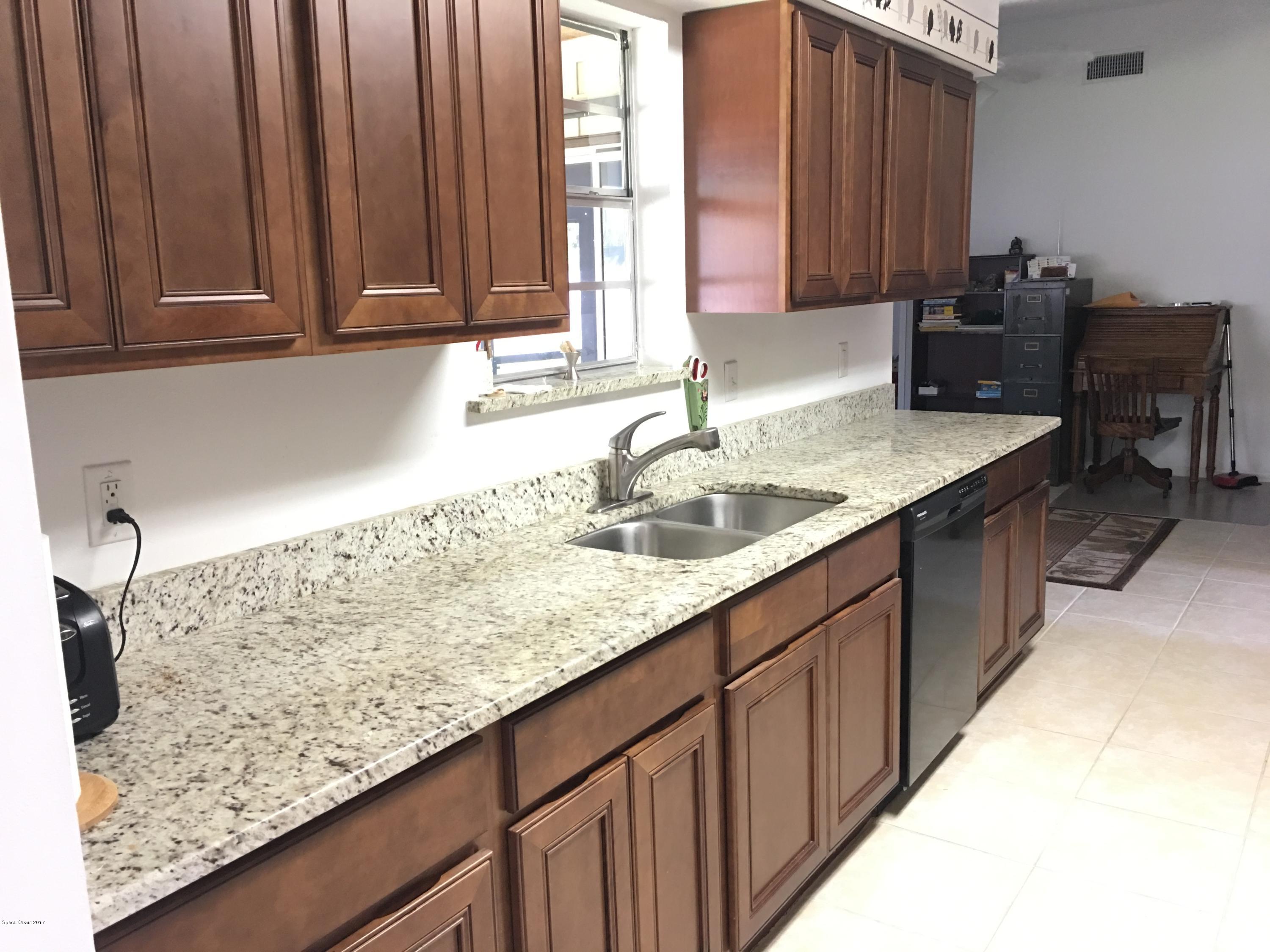 853 Furth Road Northwest Palm Bay, FL 32907 - Photo 6 of 29 a kitchen with granite countertop sink and cabinets