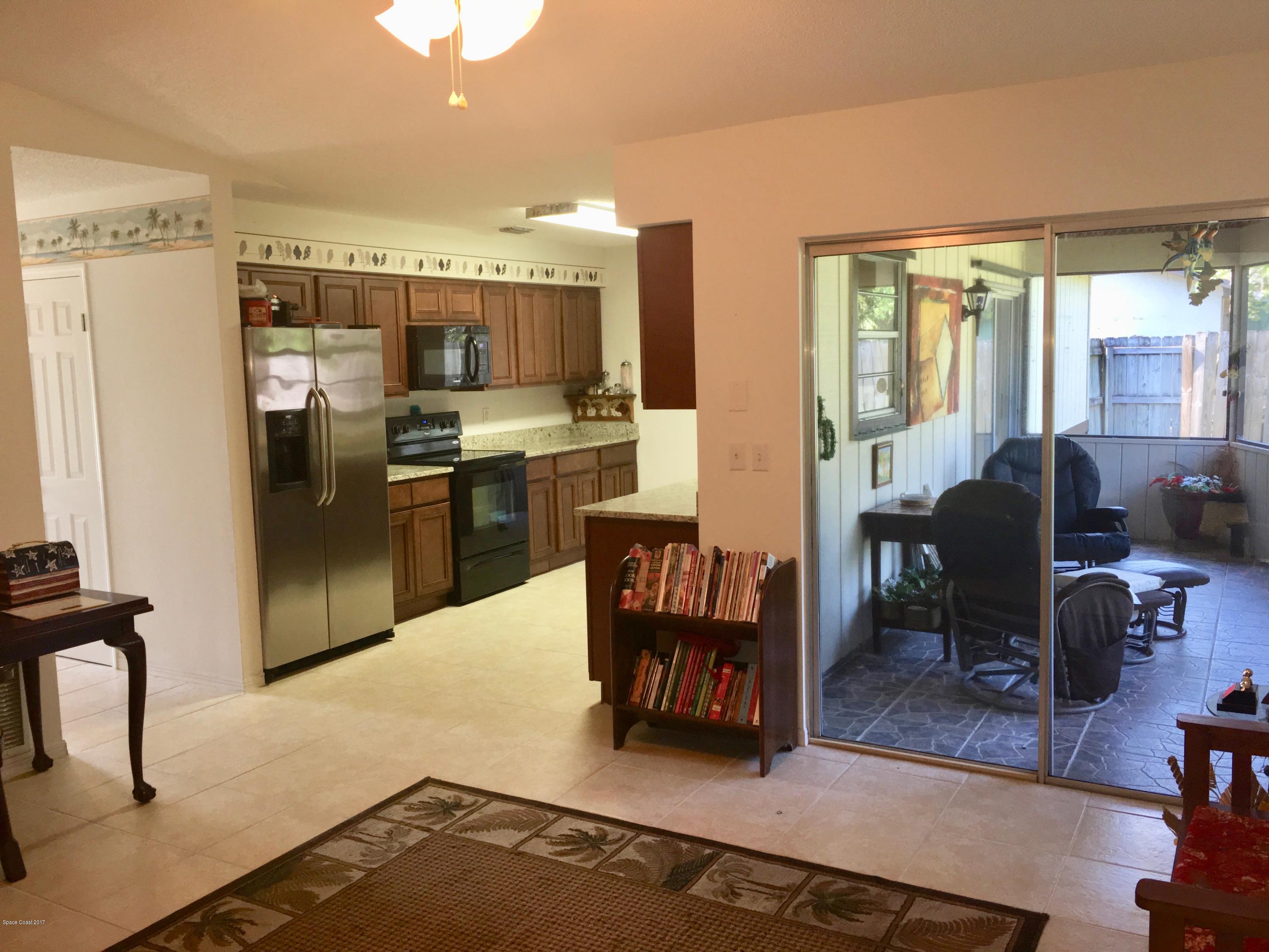 853 Furth Road Northwest Palm Bay, FL 32907 - Photo 8 of 29 a living room with stainless steel appliances furniture a rug and a kitchen view