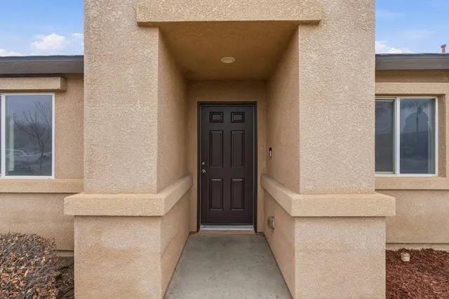 a living room with furniture kitchen view and a chandelier