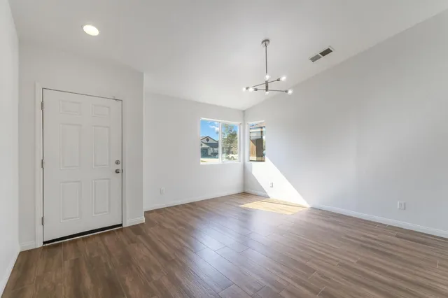 a kitchen with stainless steel appliances a refrigerator a stove a sink a table and chairs