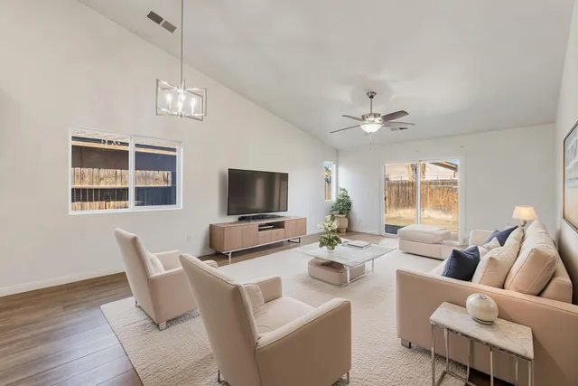 a kitchen with stainless steel appliances granite countertop a sink a stove top oven a refrigerator with wooden floors