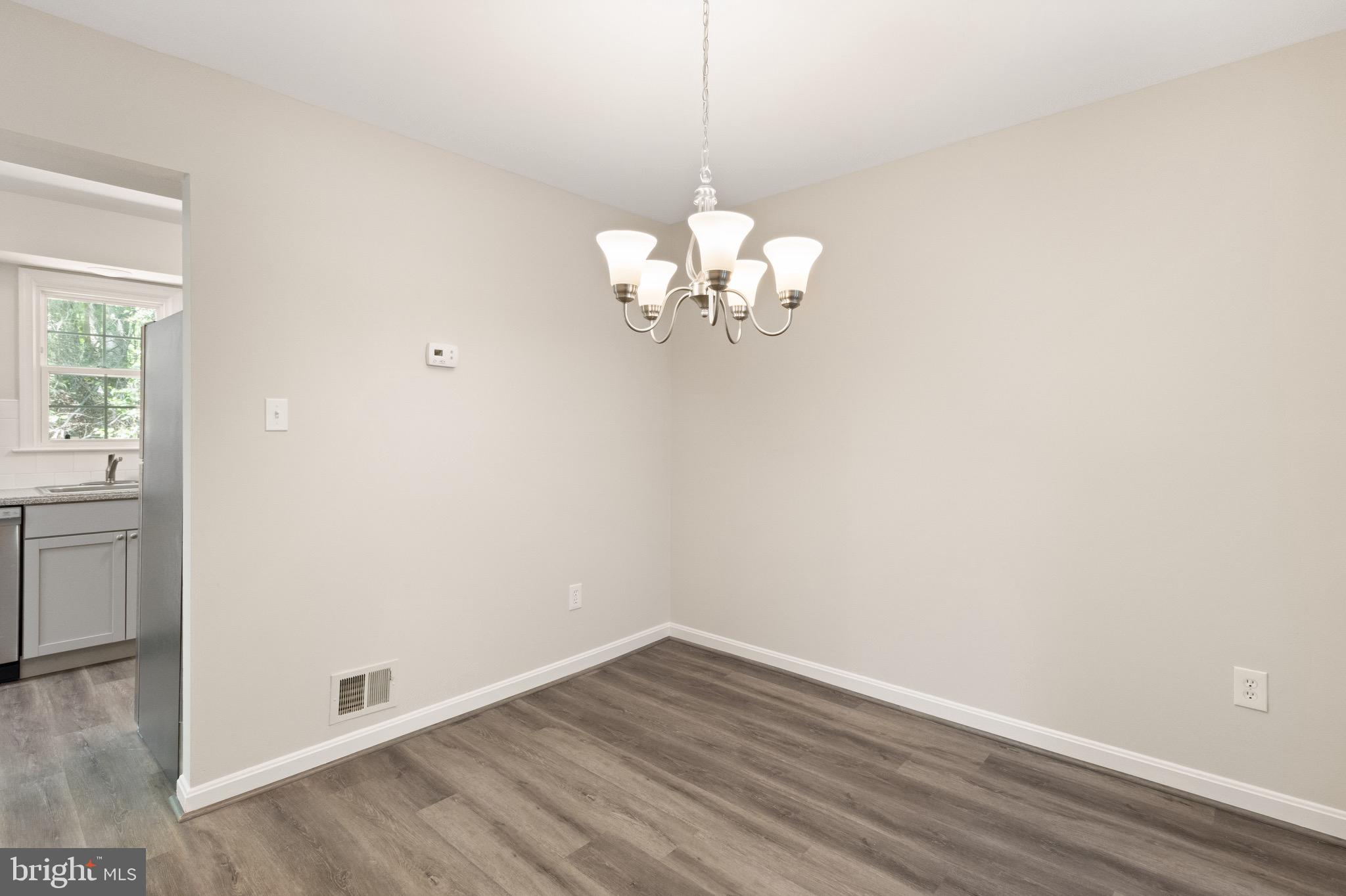 8581 Chester Grove Court Springfield, VA 22153 - Photo 6 of 38 a view of a room with wooden floor and chandelier