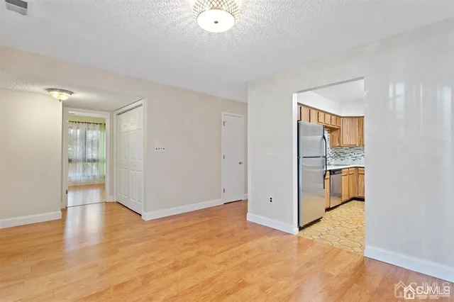 an empty room with wooden floor and white walls