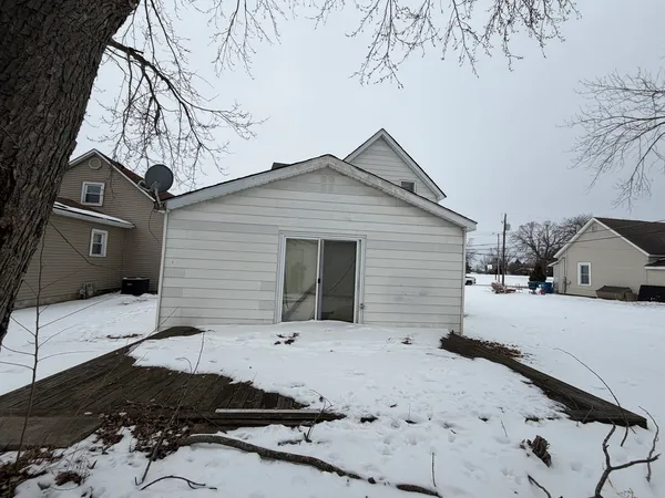 a view of a white house with a yard covered in snow