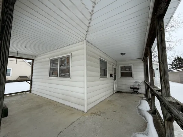 a view of a porch with a table and chairs