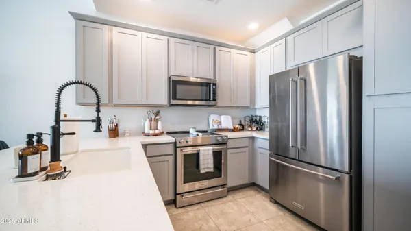 a kitchen with stainless steel appliances a refrigerator sink and microwave