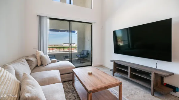 a living room with furniture a large window and a table
