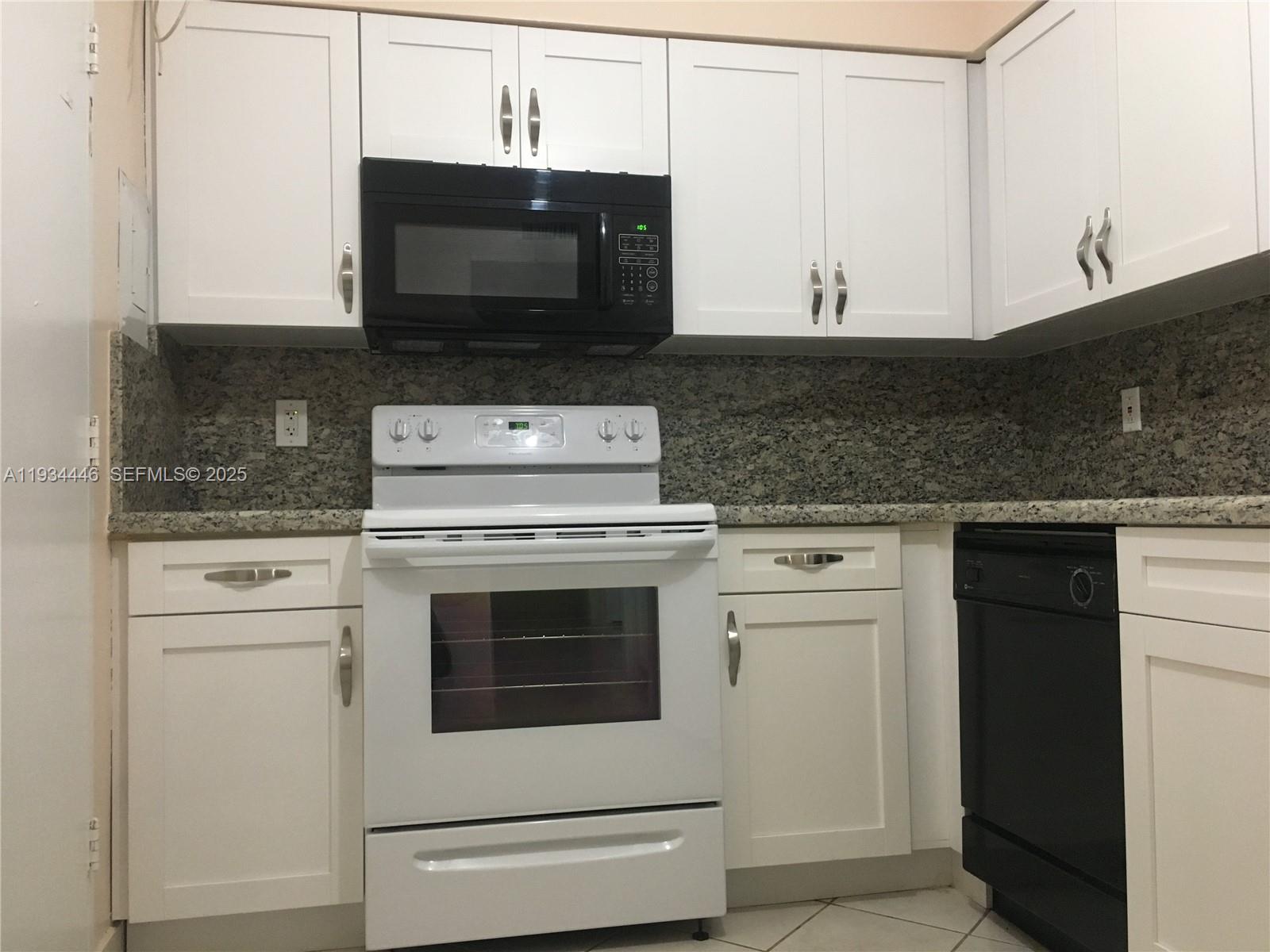 9225 Collins Avenue, Unit 305 Surfside, FL 33154 - Photo 2 of 10 a kitchen with stainless steel appliances granite countertop a stove microwave and oven