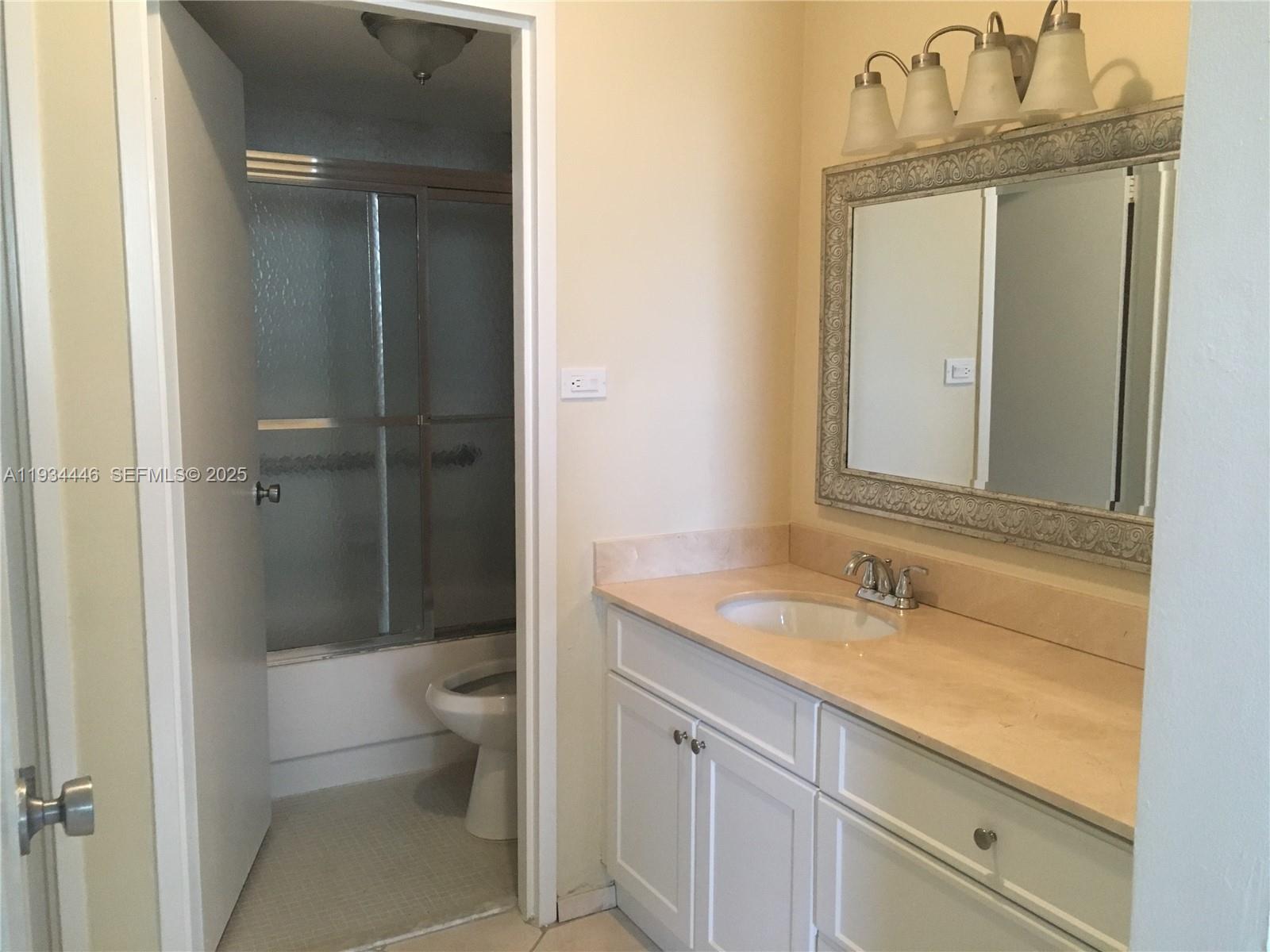 9225 Collins Avenue, Unit 305 Surfside, FL 33154 - Photo 5 of 10 a bathroom with a sink a toilet and shower