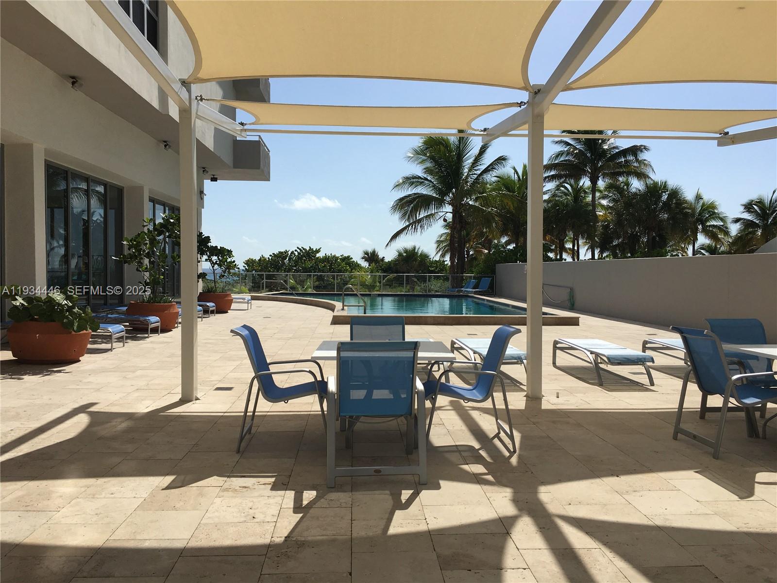 9225 Collins Avenue, Unit 305 Surfside, FL 33154 - Photo 9 of 10 a view of a patio with dining table and chairs with wooden floor