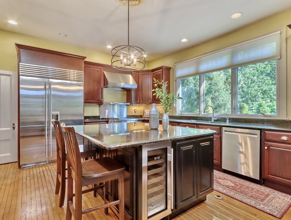5 Chestnut Street Melrose, MA 02176 - Photo 15 of 42 a kitchen with stainless steel appliances granite countertop a stove top oven a sink with granite countertops and chairs