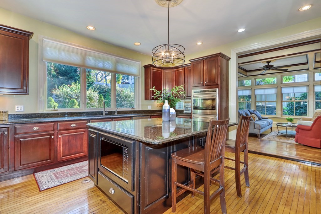 5 Chestnut Street Melrose, MA 02176 - Photo 16 of 42 a kitchen with a stove a sink dishwasher a dining table and chairs with wooden floor
