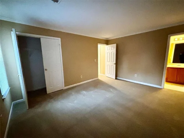 an empty room with closet and windows