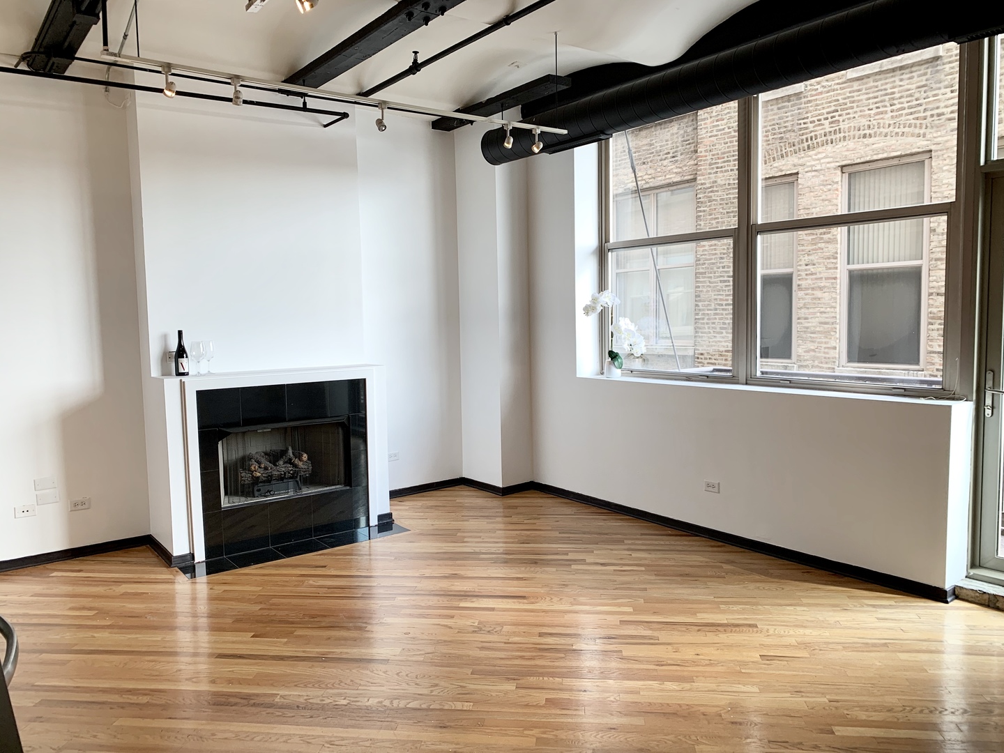 500 South Clinton Street, Unit 417 Chicago, IL 60607 - Photo 4 of 18 a view of an empty room with wooden floor fire place and windows