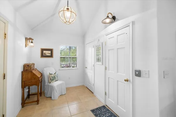 a living room with furniture a large window and chandelier