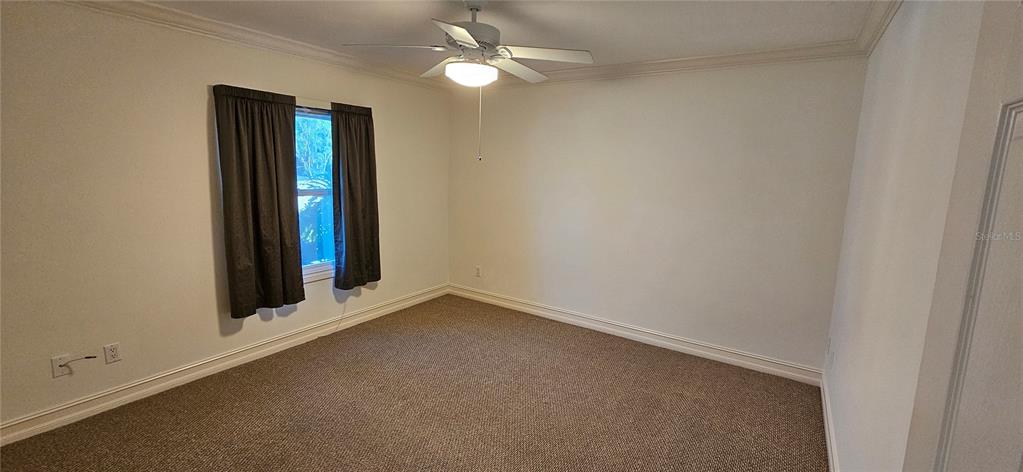 11729 Timberline Circle Fort Myers, FL 33966 - Photo 13 of 33 an empty room with a window and ceiling fan