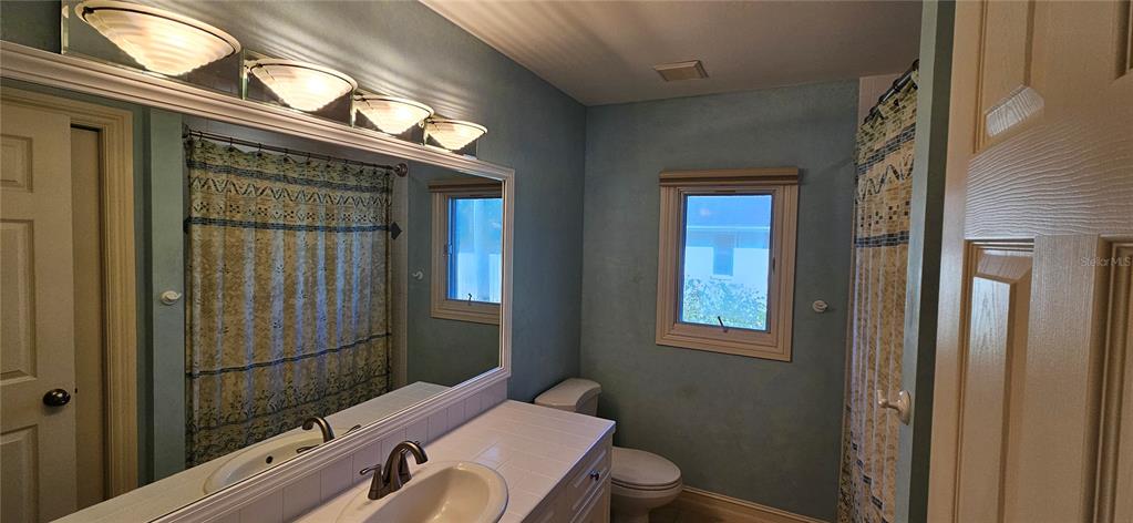 11729 Timberline Circle Fort Myers, FL 33966 - Photo 14 of 33 a bathroom with a toilet a sink and mirror